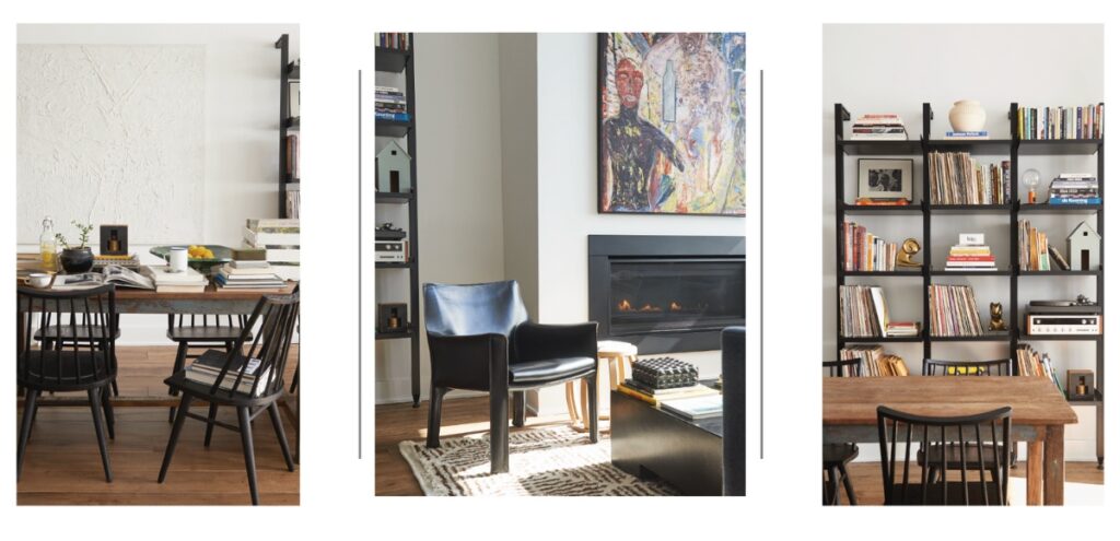 A stylish, modern living room with a black leather armchair, a low black coffee table, a graphic patterned rug, and a fireplace, featuring abstract art above the mantel in a renovated storefront home.