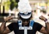 Giving Guide 2025: A+ Schools A man in a marching band hat carries a snare on his body.