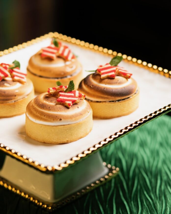 Caribbean Christmas Tart TABLE Magazine Four smaller circle tarts with peppermint candies on top, all on a green table top.