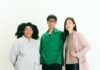 The 59th Carnegie International Focuses on Collaboration Three art curators stand against a white wall in a group.