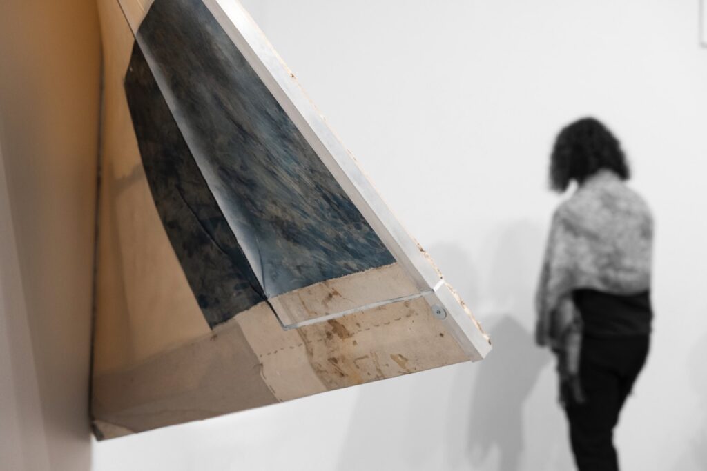 An angular painting coming off of a gallery wall.