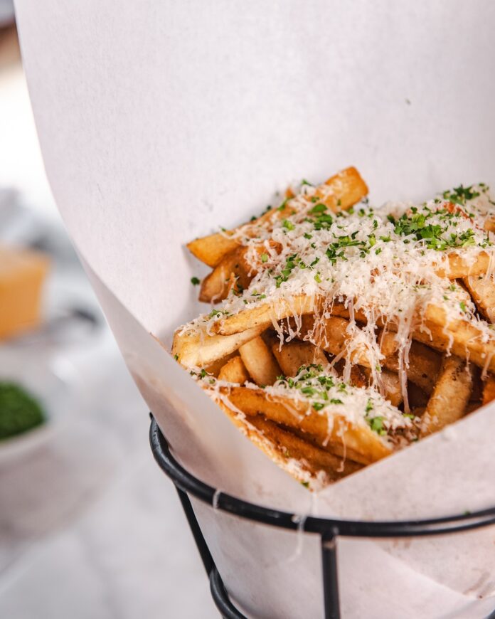 A basket full of truffle fries with cheese on top at a Pittsburgh restaurant.