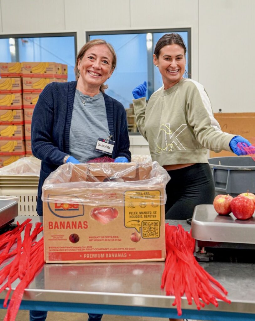 Two women pack a box with apples at a food resource center in Western Pennsylvania.
