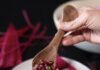 Cook Up These New Year Good Luck Recipes with the Help of Pittsburgh Sources A person spoons a filling onto a hot pink tamale.
