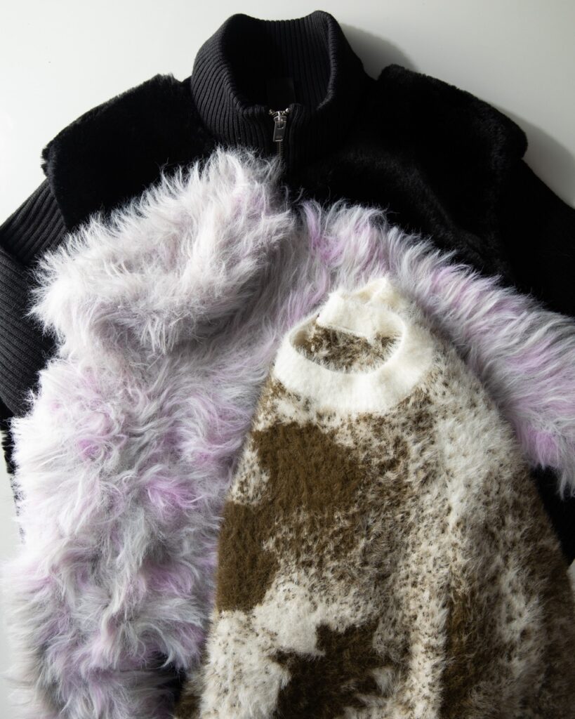 A stack of women's jackets and sweaters.