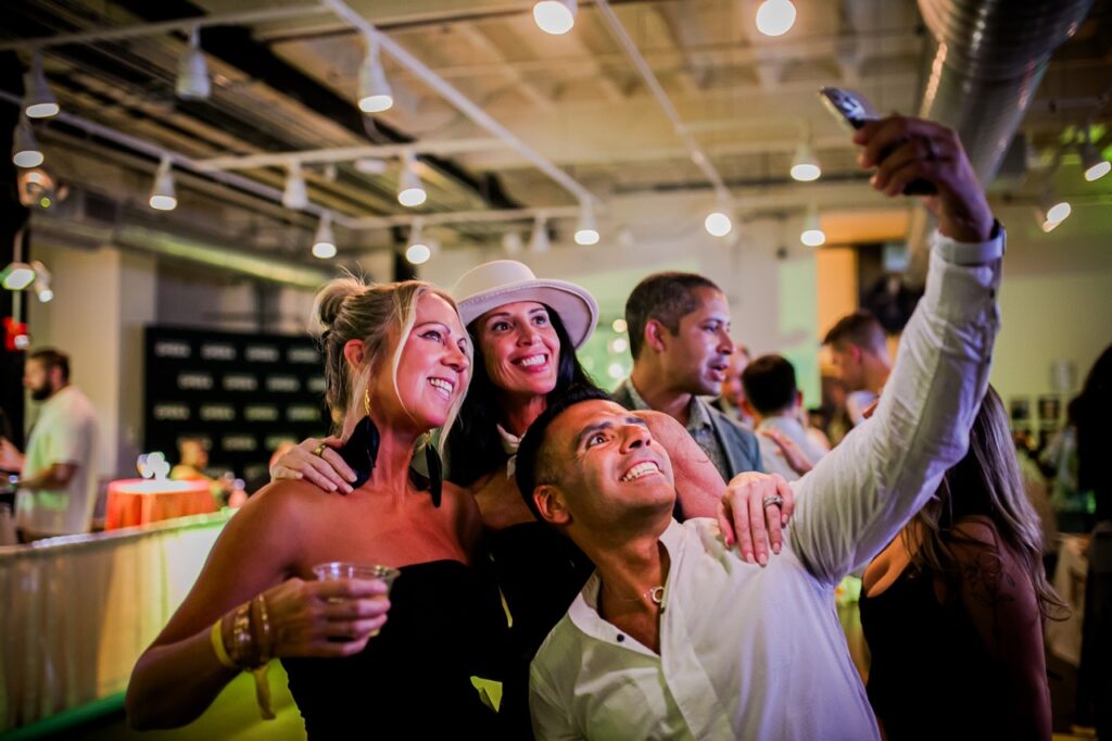 A group of two women and a man take a selfie.