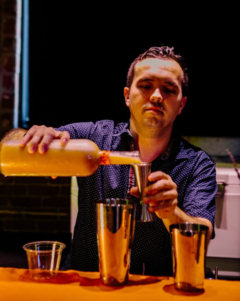 A bartender mixes a cocktail at the bar.