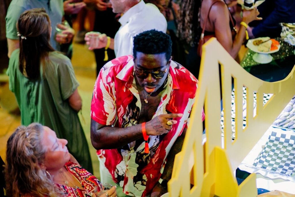 A man in a red and white shirt with a fake yellow bridge.