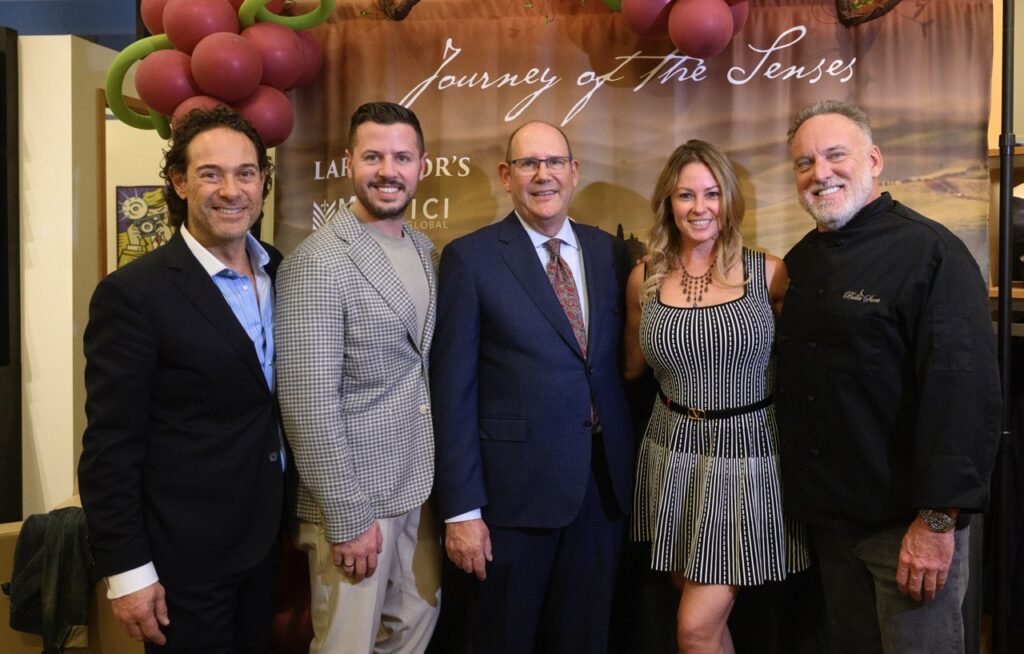 Four men and a woman stand in front of a banner for Journey of the Senses