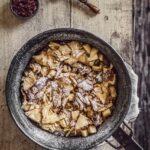 A kaisercharrn in a cast iron pan on a wood table.