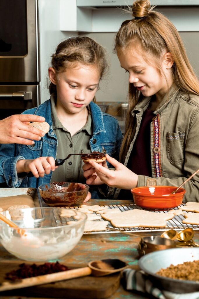 Ganache-Stuffed Chocolate Chip Cookies Kids spreading ganache on a cookie