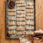 Drizzling Icing over cookies on baking sheet