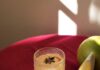 Grapefruit Chai Masala “Mimosa” A chai masala good luck mimosa with grapefruit juice sits on a red table top with a star anise garnish in the glass and citrus slices nearby.