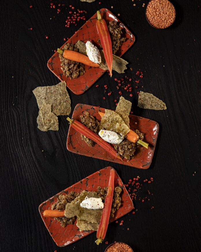 Pickled Baby Carrots with Lentils Three orange rectangular plates with pickled baby carrots, smoked labneh, and lentils.