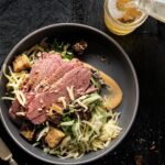 Reuben salad with sliced meat on top and a drizzle of thousand island dressing.