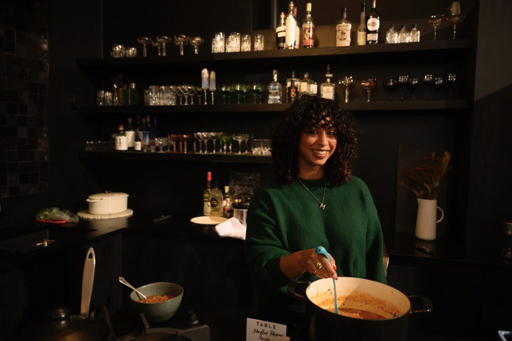 A woman stirs her pot of soup.