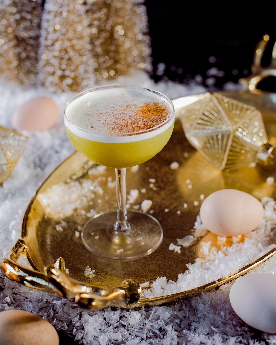 A Grey Goose cocktail staged with a few eggs and Christmas decorations for a golden, festive touch