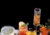 50 Holiday Cocktails to Serve to Your Friends and Family Twelve cocktails for Twelve Days of Christmas shot in a side view on a cheery, holiday decor table
