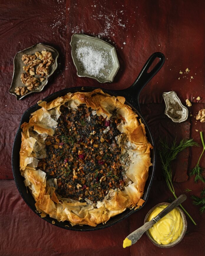 Winter Greens Recipes Chard and Feta Pie in a skillet with things around it