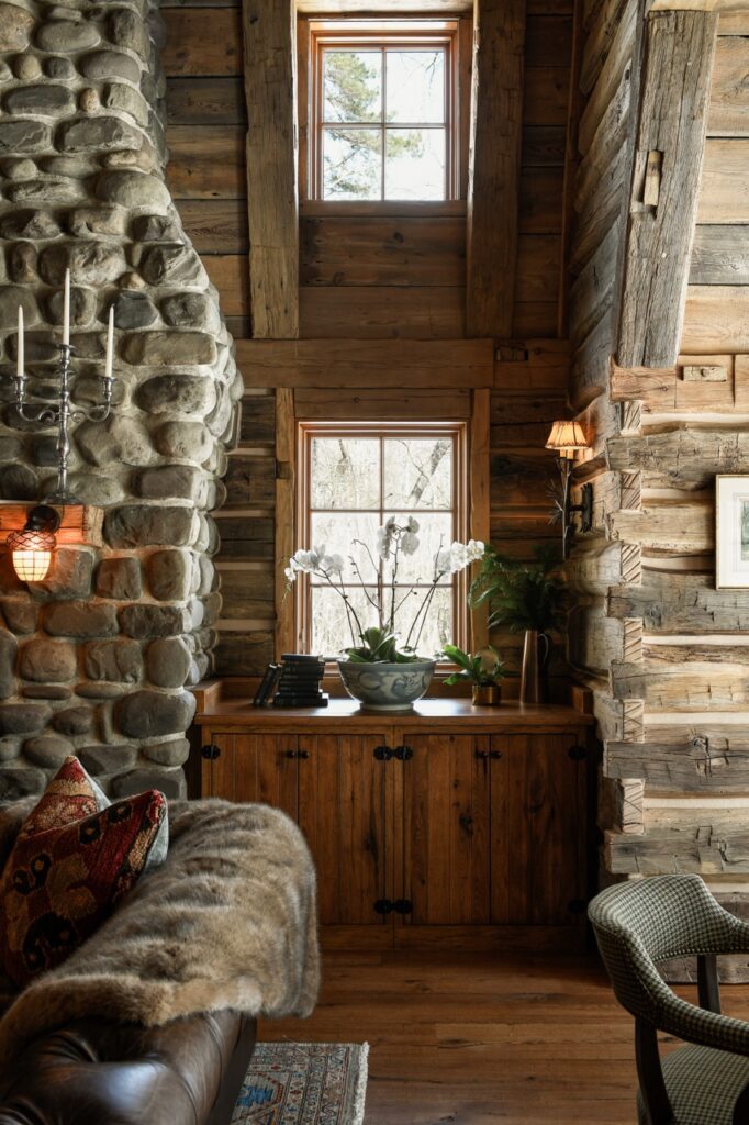 White orchids in front of a window in a wood cabin looking space.