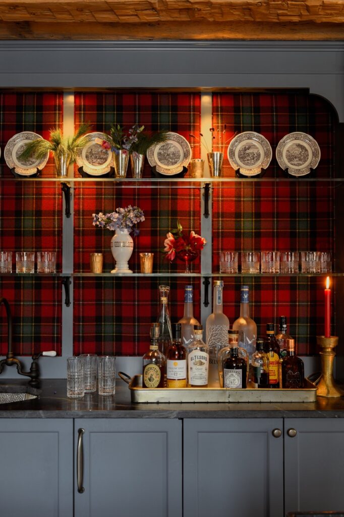 A china cabinet in front of a plaid wall.