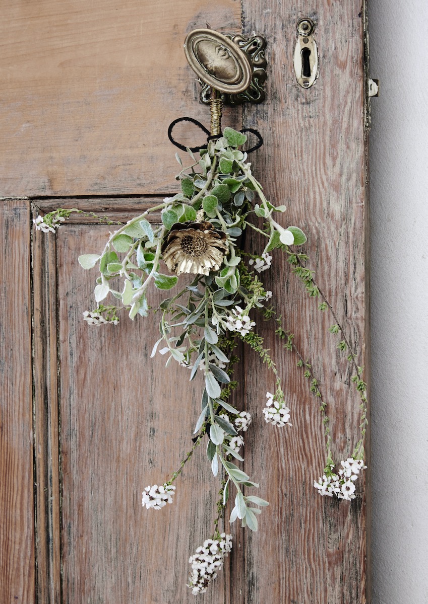A single sprig of a Christmas wreath on a doorway