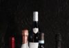 Gift These Wine Bottles This Holiday Season Five bottles of wine stacked on a table for gifting.