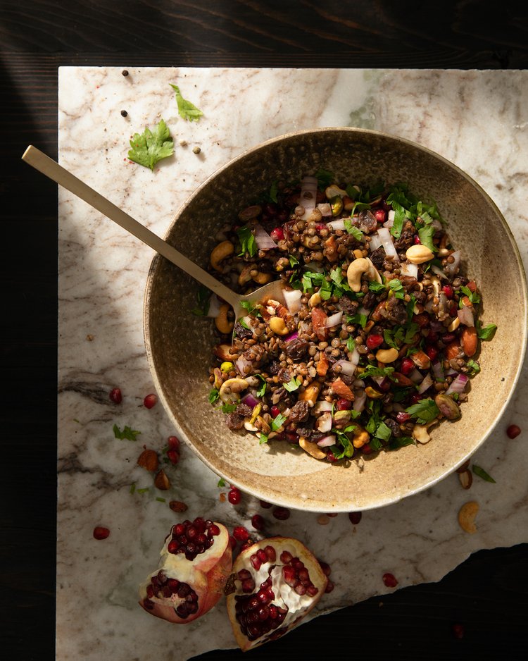 A bowl full of french lentils with a spoon sticking out of it.