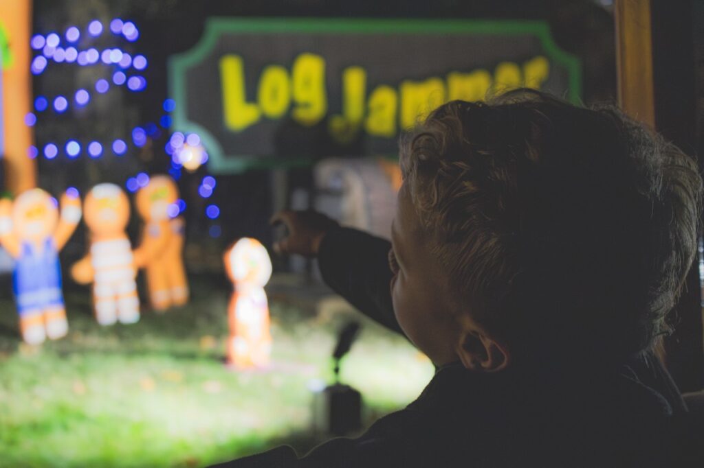 A young boy points at gingerbread men in a display.