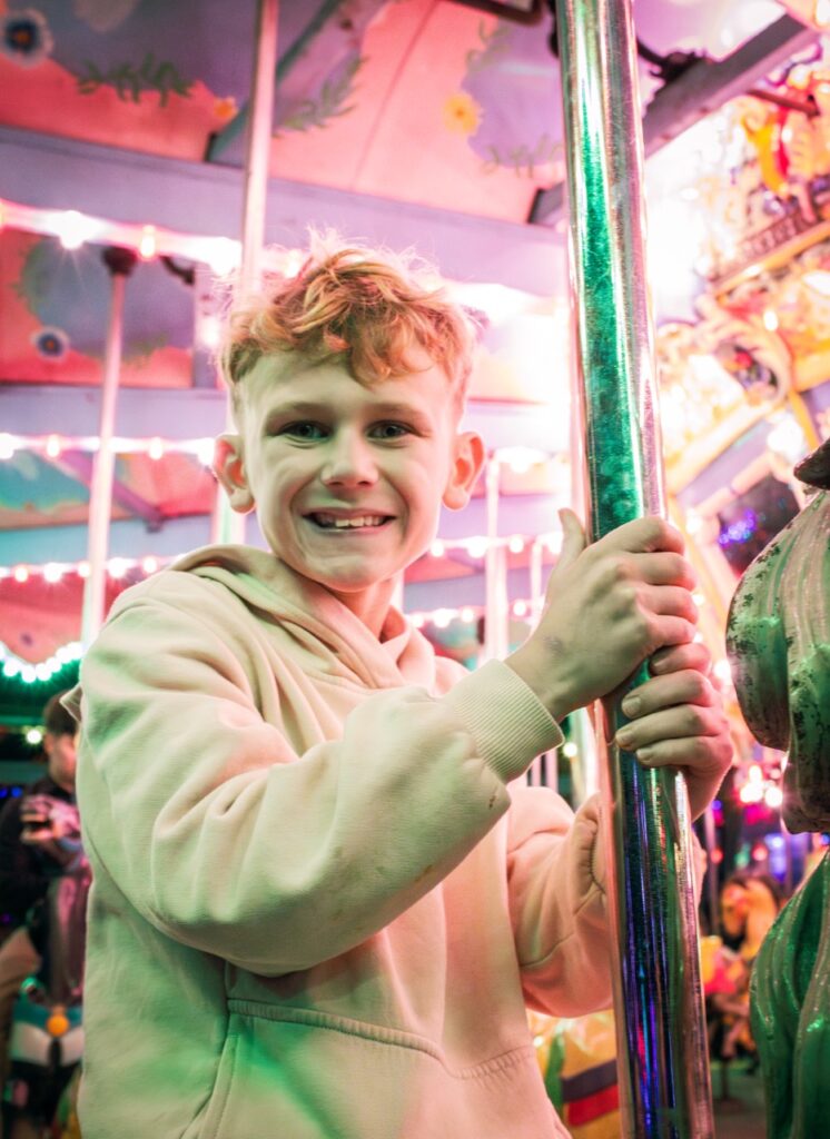 A boy holds onto a metal pole in front of him.