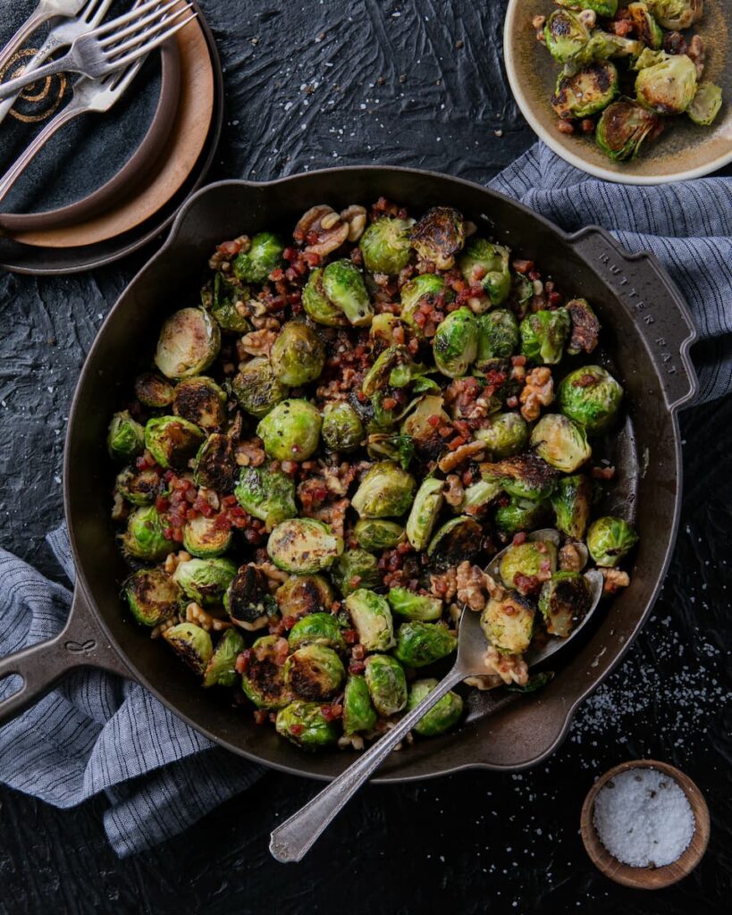 Seared Brussels Sprouts with Walnuts & Pancetta, a delicious side dish, cooked in a cast-iron skillet with Dijon mustard and champagne vinegar for added flavor.