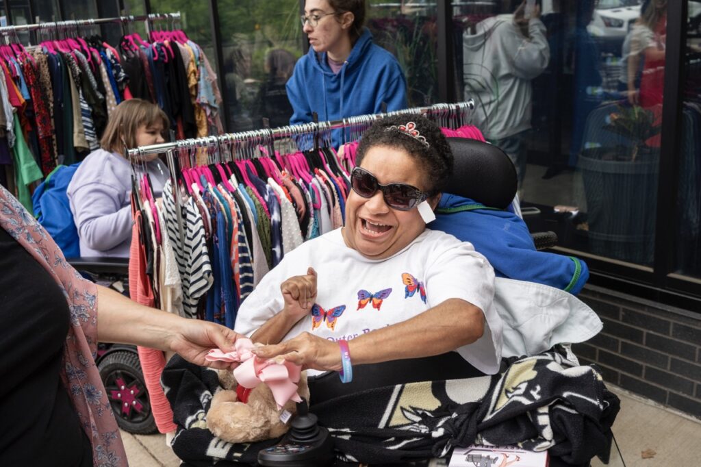 A woman in an electric chair with sunglasses and a white shirt.