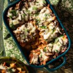 A pan of Wild Boar Pappardelle with a plate of a slice beside it.