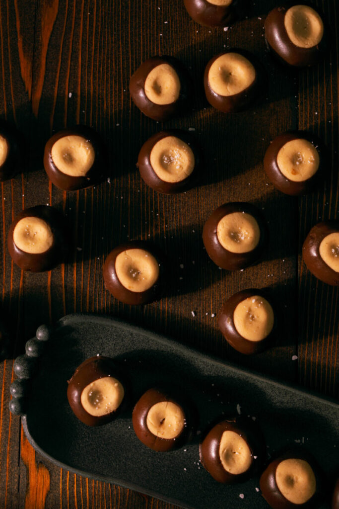11 buckeyes sit spread apart on a wooden table