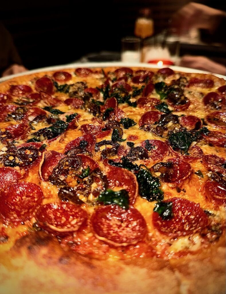 Pepperoni on a pizza with jalapeños in the cheese too.