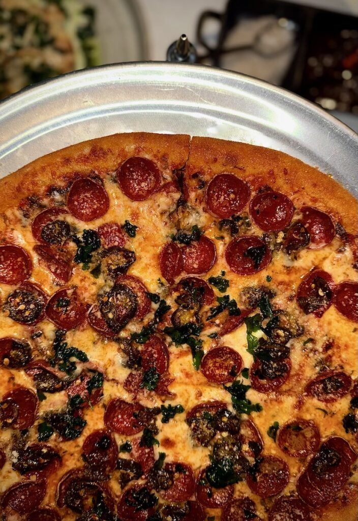 A pepperoni pizza on a silver tray.