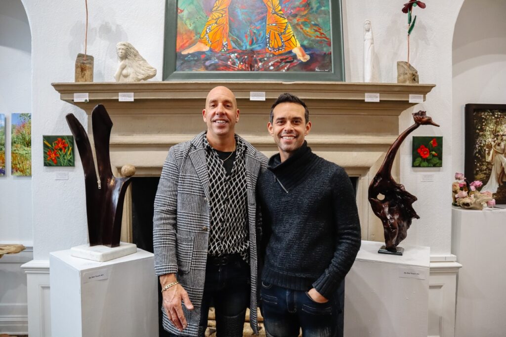 Two men stand in the center of an art gallery space.