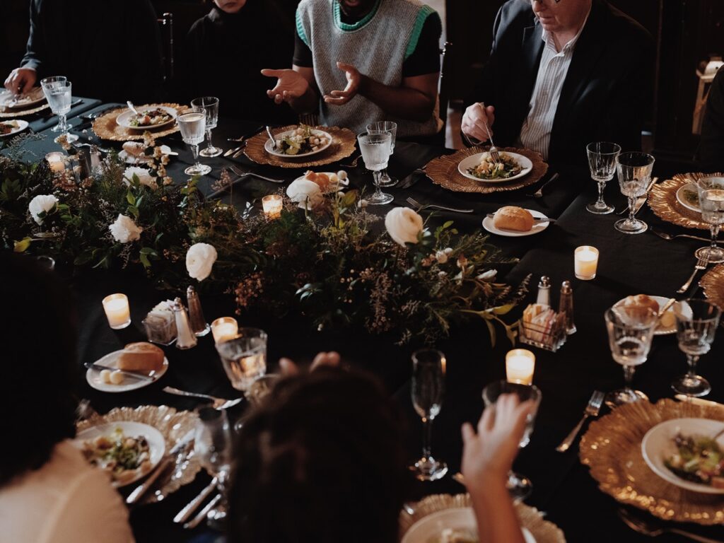 An array of place settings and flowers on a table.