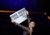 January–March 2026 Pittsburgh Theater Schedule & Show Guide A woman on a theater stage holds up a large newspaper.