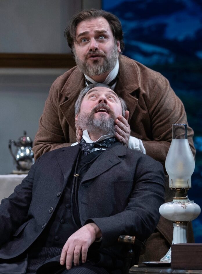 One man moves another mans head to look upward on a Pittsburgh stage.