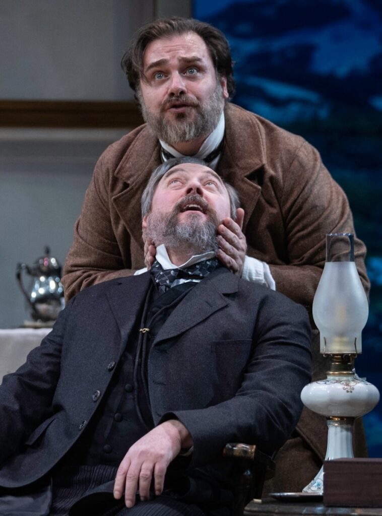 One man moves another mans head to look upward on a Pittsburgh stage.