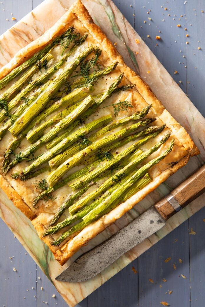 A rectangular Asparagus Tart with stalks of asparagus lined on top of the pastry.
