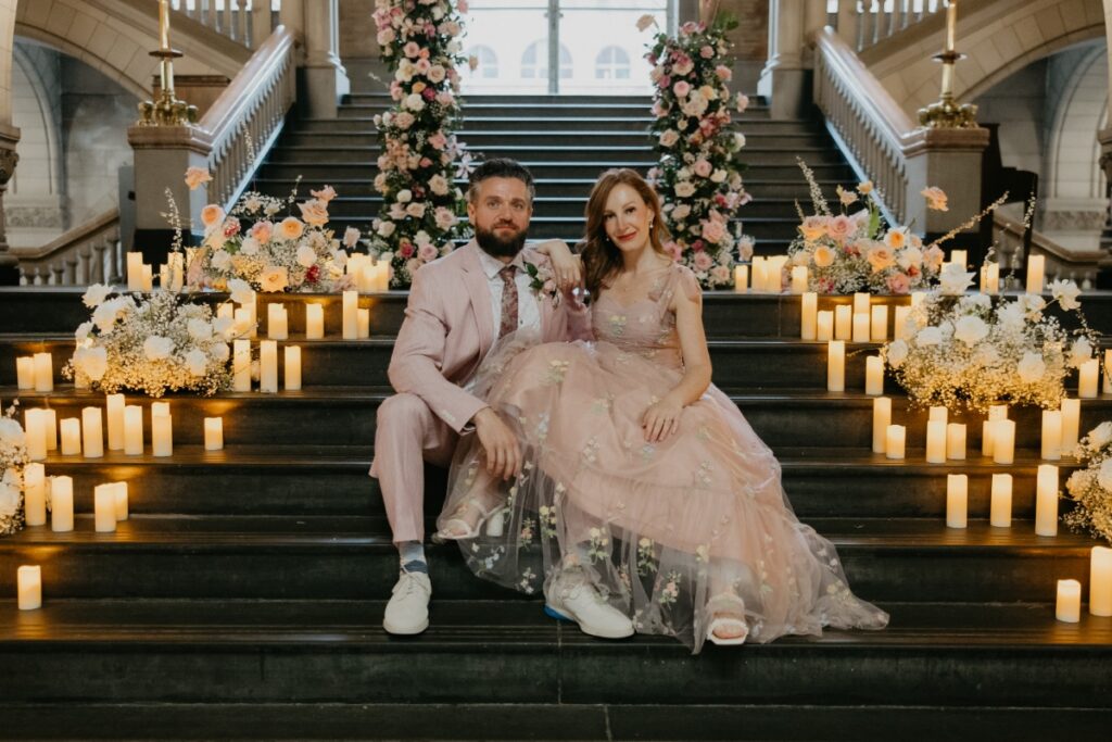 Bride and Groom sitting on the candlelit Grand Staircase of the Allegheny County Courthouse for their wedding renewal.
