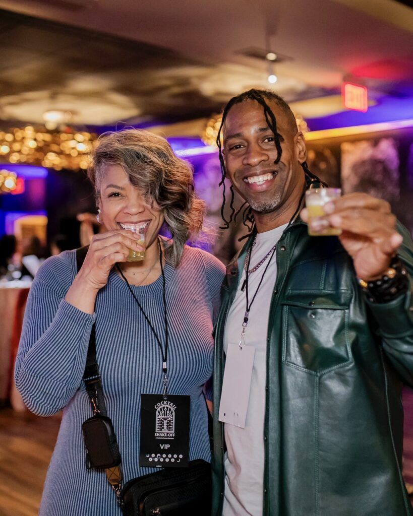A man and woman hold small glasses up.