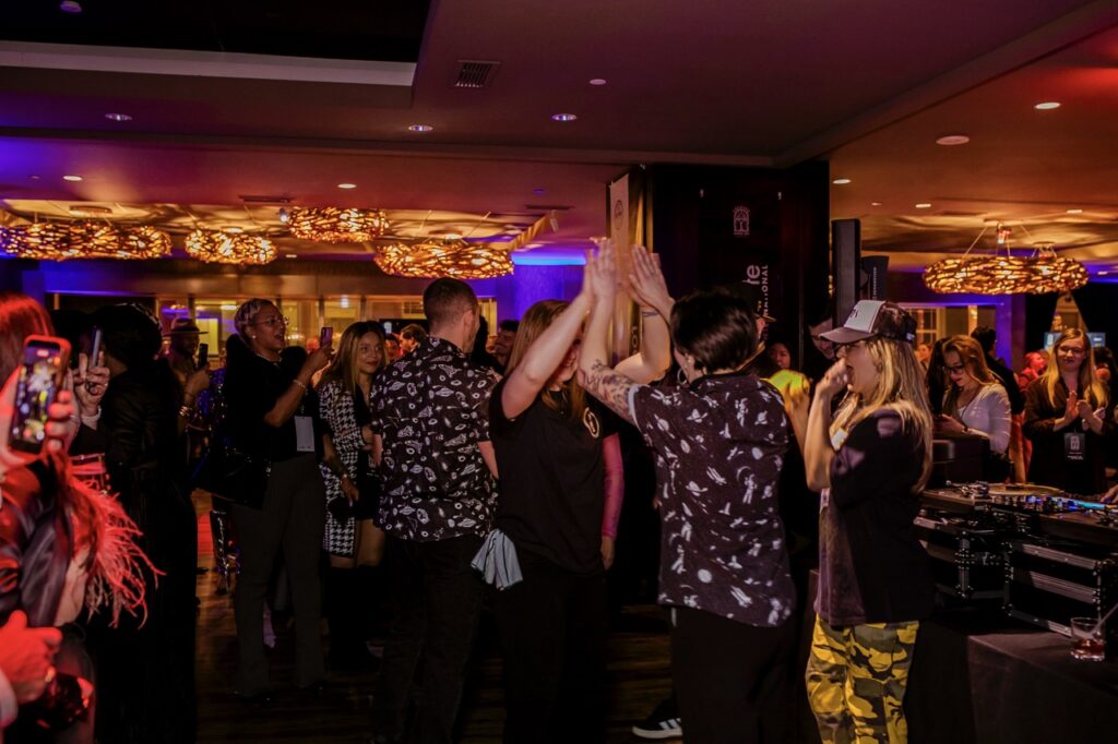 A group of people high five on the dance floor.