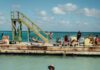 Adult Spring Break Trips for a Relaxing Getaway from Pittsburgh A bunch of people wade in the water by a wood deck.