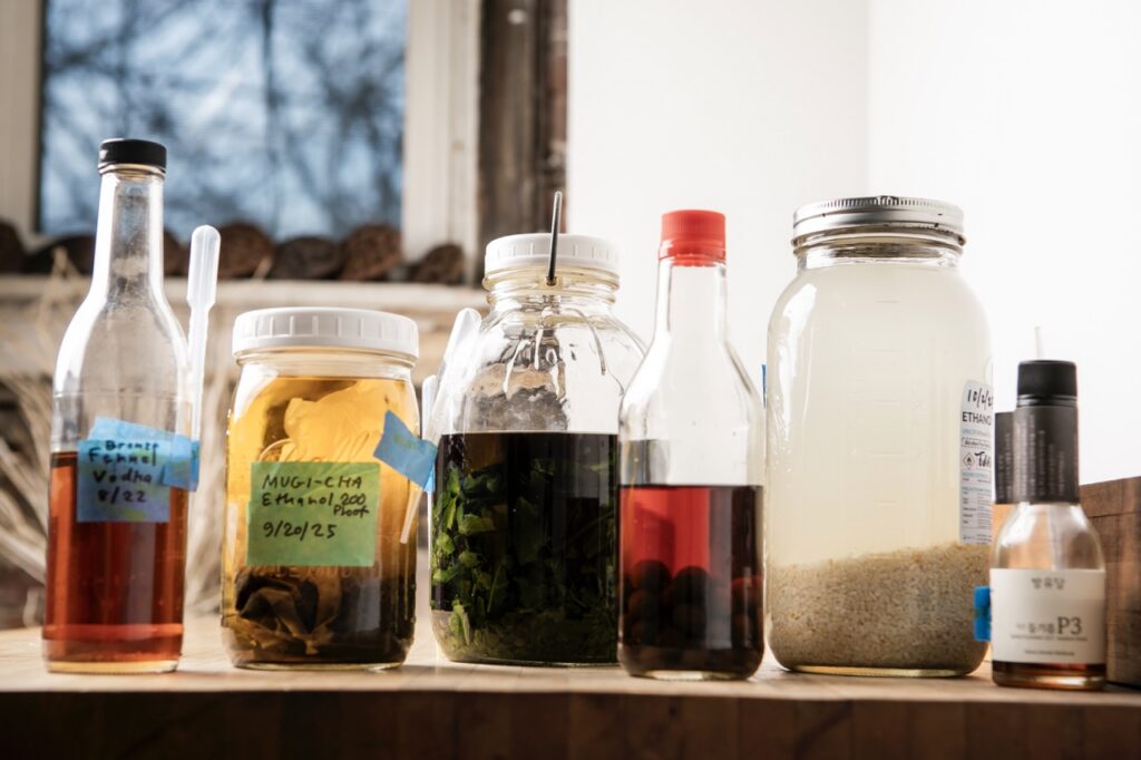 Various jars of seeds and distillates sit on a counter.