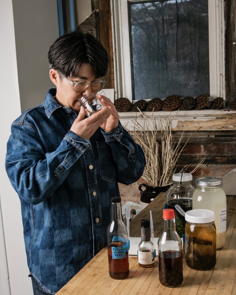 ginger Brooks Takahashi smells a jar of seeds.