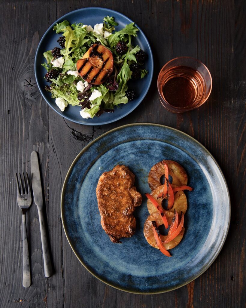 Pork chops, pineapple, and peaches on the grill make for a sweet summertime meal.

