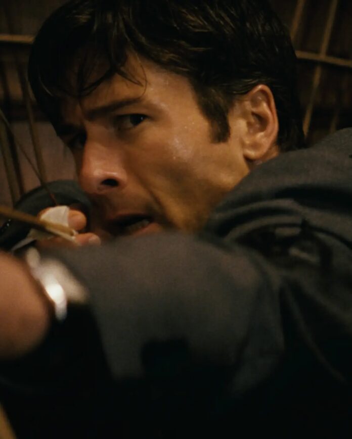 Glenn Powell holding a bow in how to Make a Killing.